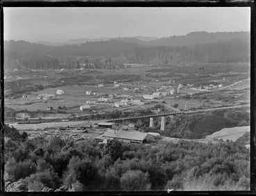 Image: View over the settlement of Kakahi, with sawmill, stacked timber, rail yards and bridge and residential houses with forest covered hills beyond, Manawatu-Whanganui Region
