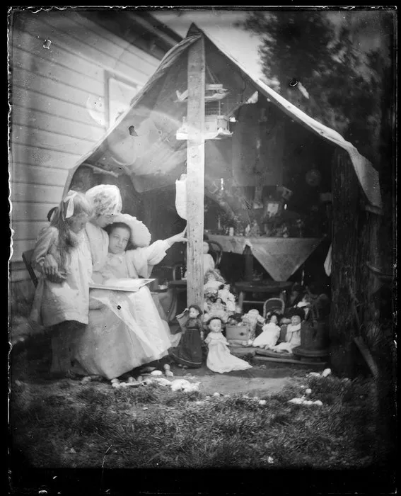 A woman and two young girls reading outside