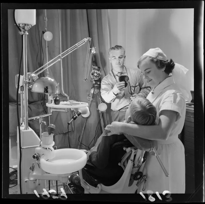 A United States Television cameraman filming a dental nurse at work