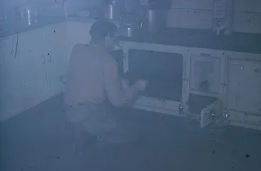 Image: Eric Clague rescuing burnt biscuits, Campbell Island