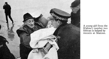 Image: A young girl from the Wahine's number two lifeboat is helped by rescuers at Seatoun