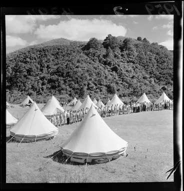 Image: Boys' Brigade camp, Wainuiomata, Lower Hutt City, Wellington region, showing tents and boys lined up around perimetre of campground