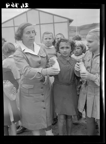 Image: Teacher Julia Rolińska passes a bottle of milk to Stefania Serdyńska at a Polish refugee camp, Pahiatua