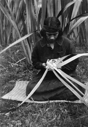 Image: Woman weaving a food basket (rourou or kono) from flax leaves, at Koriniti