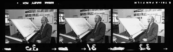 Bill Lovell-Smith at his desk with plans