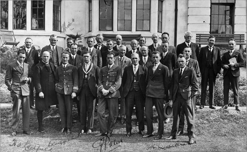 Charles Kingsford Smith with a large group of men in garden of Hamilton Hotel