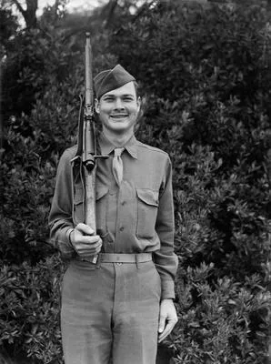 [U.S. military serviceman poses for a portrait holding rifle]