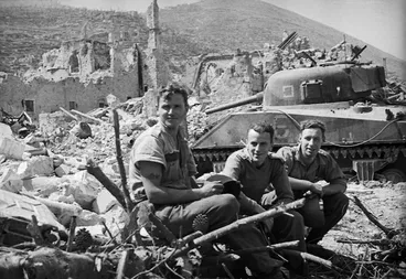 Image: Members of the 4 NZ Armoured Brigade alongside a Sherman tank, after the capture of Cassino, Italy - Photograph taken by George Kaye