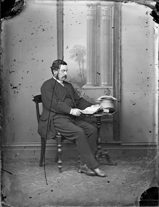 Unidentified man, seated, with an open book