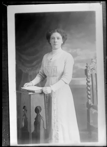 Image: Studio portrait of an unidentified woman with necklace and holding a book, Christchurch
