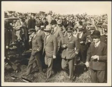 Image: Charles Kingsford Smith and Charles Ulm in RAAF uniform, with Mayor of Auckland, George Baildon, walking through crowd after landing at Auckland, New Zealand, September 1928