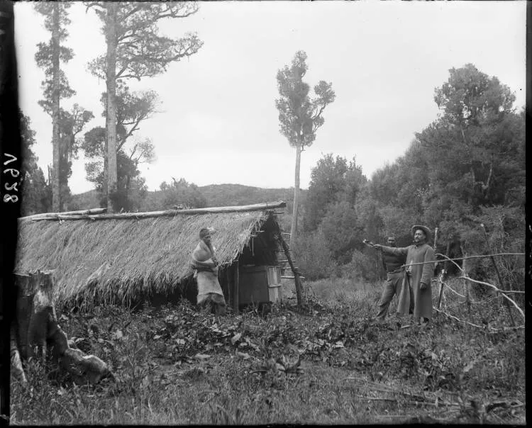 Three men by a whare at Hangatiki in the Waikato, 1900