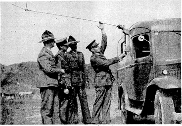 Image: Evening Post" Photo, A general view of the telegraph operating room at the Wellington General Post Office, through ivhich the messages relating to the progress of the General Election will pass on Saturday evening to the Chief Electoral Officer, and thence to the results board in front of the "Evening Post" building. A new aerial base fitting for the, army wireless vans, exhibited recently at Trentham Camp. Major E. H. R.Green, Assistant Director of Signals, Captain G. F. Heal, Staff Officer Signals, and Lieutenant E. V. Harwood, Adjutant Central Depot New Zealand Corps of Signals, are seen inspecting the new fitting. (Evening Post, 12 October 1938)