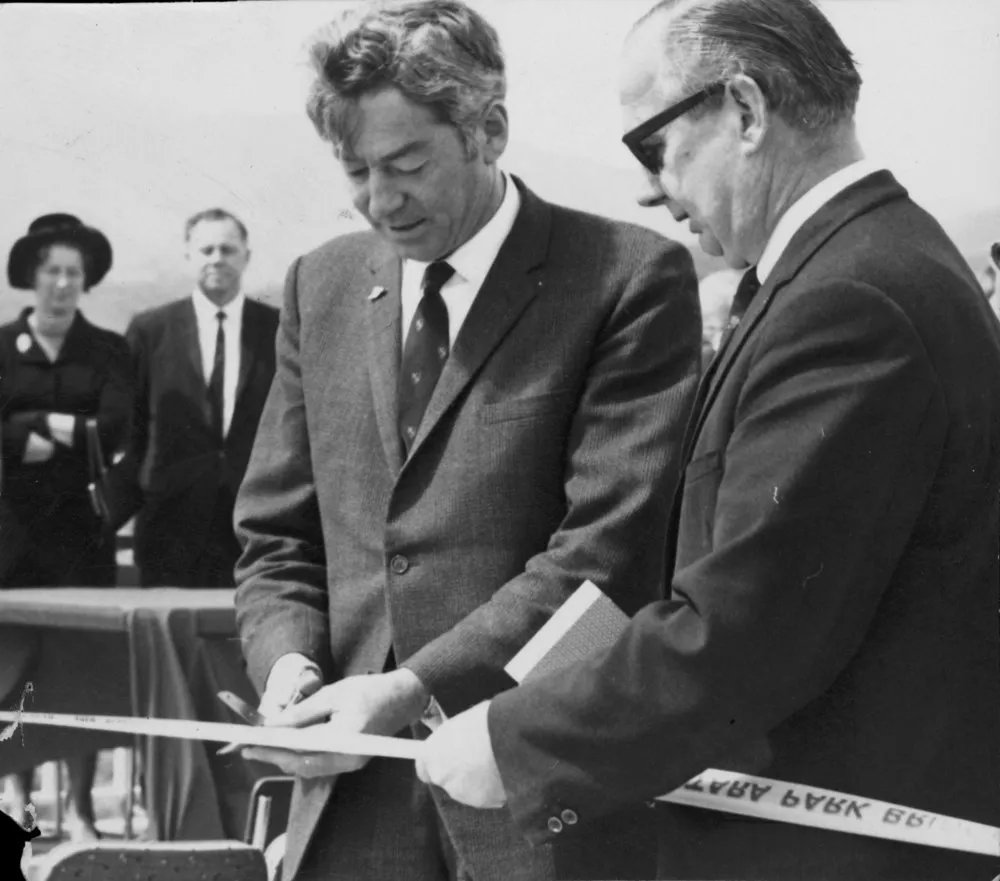 Totara Park bridge opening 3B; Rt. Hon David Thomson cutting tape; Ron Bailey M P and wife in background.