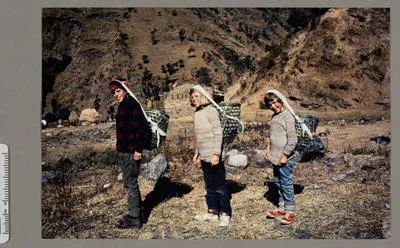 [Peter, Sarah and Belinda Hillary with baskets strapped to their heads]