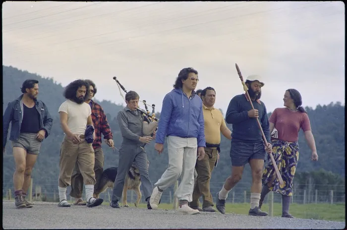 Marchers on the road, including a Highland piper