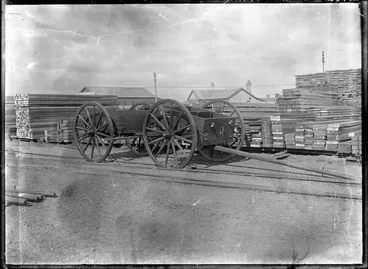 Image: A timber yard with piles of sawn timber, and a cart in the foreground.