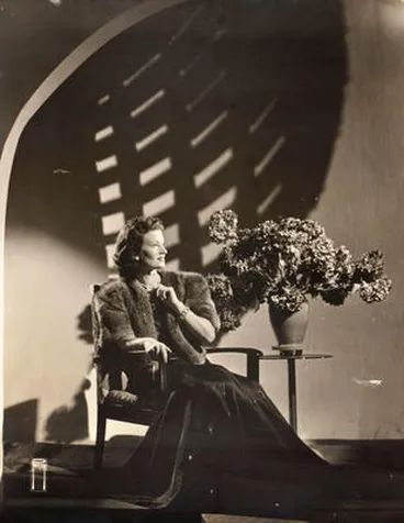 Image: (Woman in fur jacket seated with hydrangeas)