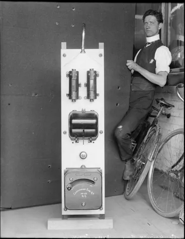 Image: Canterbury Engineering Company equipment, perhaps a boiler, with a man apparently trying to fix it, and his bicycle