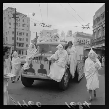 Image: Unidentified students, during capping procession in Wellington, wearing white costumes, including a truck with a sign reading 'They Need You, Verwoerd Craven'