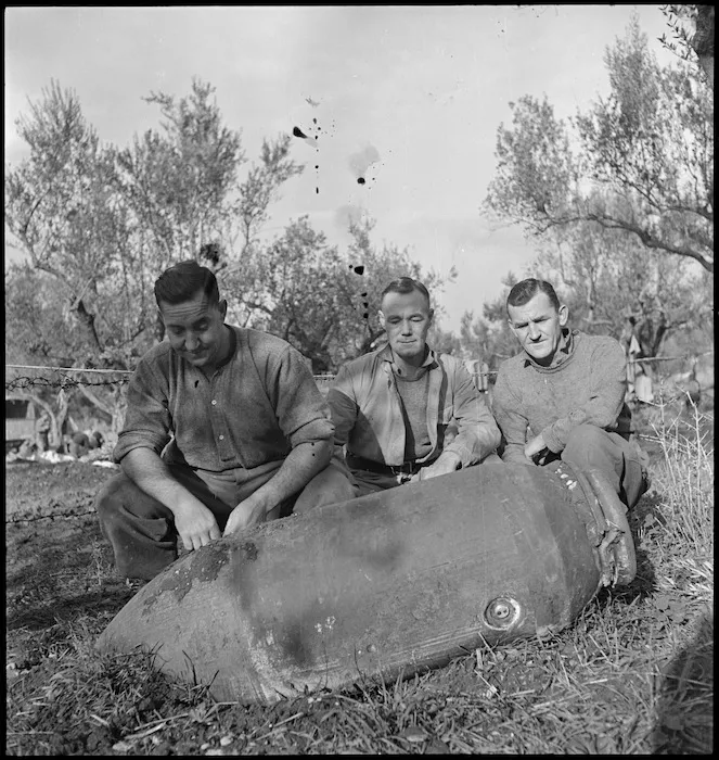 Three NZ soldiers with unexploded bomb that rolled away from house they occupied in Italy, World War II - Photograph taken by George Kaye