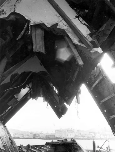 Image: C & A Odlin Timber & Hardware Co Ltd: 1969 Looking through part of the wreck of the vessel "Wahine" lifted from the Wellington Harbour seabed (sank 10Apr1968), head office building in background