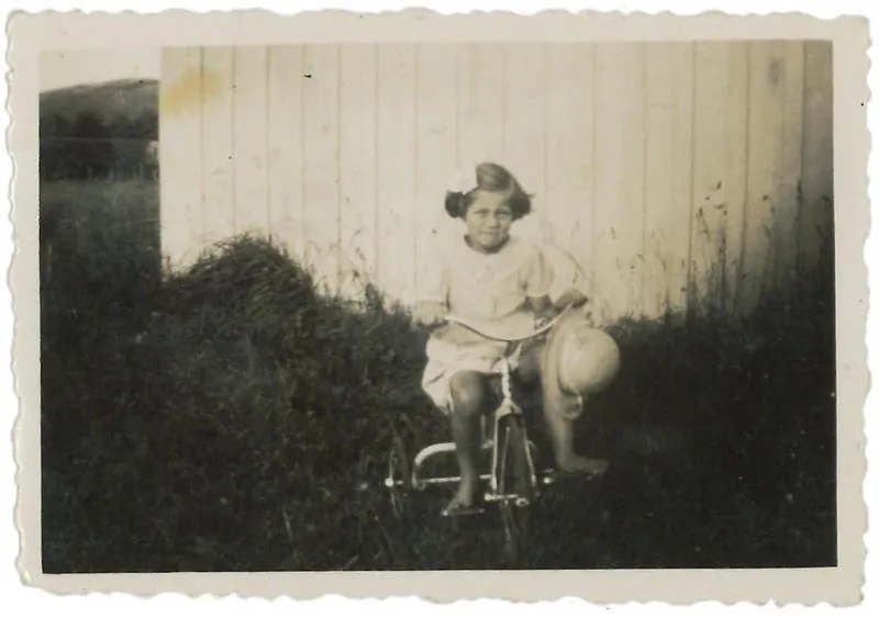 Young girl on tricycle in garden