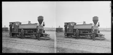 Image: Steam locomotive at railway yards, including unidentified railways workers and a small girl seated in train cab, Dunedin area, Otago Region