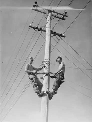 Image: [Portrait of two Servicemen up a telephone pole]