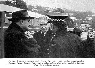 Image: Captain Robertson confers with Union Company chief marine superintendent Captain Arthur Crosbie (left) and a police officer after being landed at Seatoun Wharf by a private launch