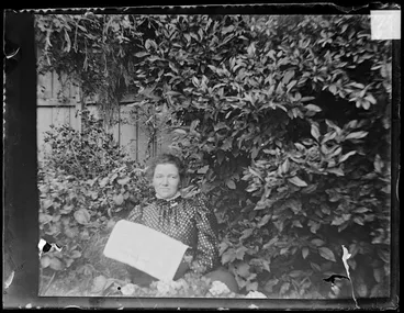 Image: Amy Kirk with newspaper in garden
