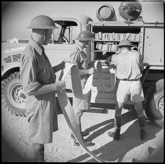 Flaking the hose back onto vehicle during NZEF Base Fire Brigade practice, Maadi, Egypt