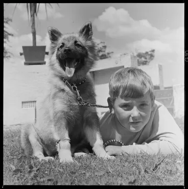 Image: Young boy on the grass with his puppy