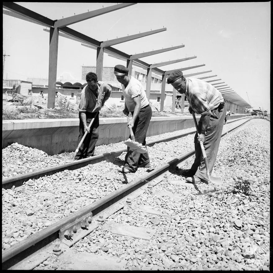 "Fifteen Miles To Go" [Men working on railway tracks]