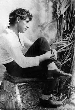 A young man sitting on a stage prop : photograph