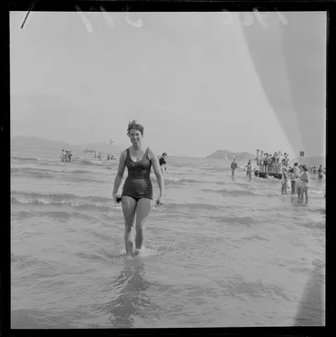 Image: An unidentified young woman who just completed the Somes Island Petone swim on Petone Beach with children looking on, Wellington City