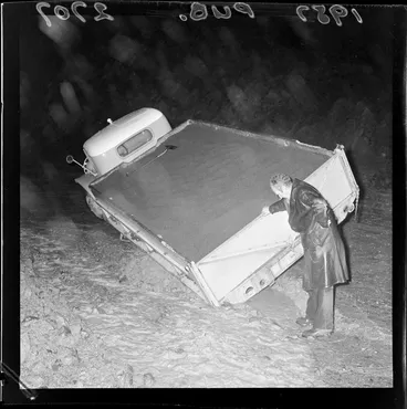 Image: An unidentified man looking at his truck that stuck in mud on Wainuiomata Hill, Lower Hutt, Wellington Region