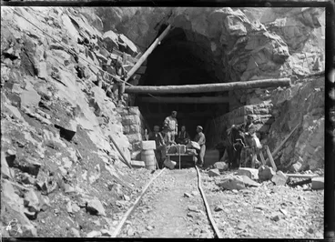 Image: Otira Tunnel, Westland District, with a man tending to a horse and men on a cart and working in the tunnel entranceway