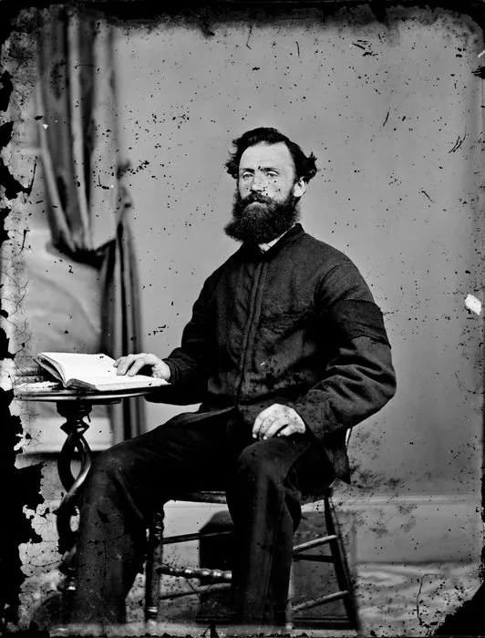 Unidentified man, seated, with an open book