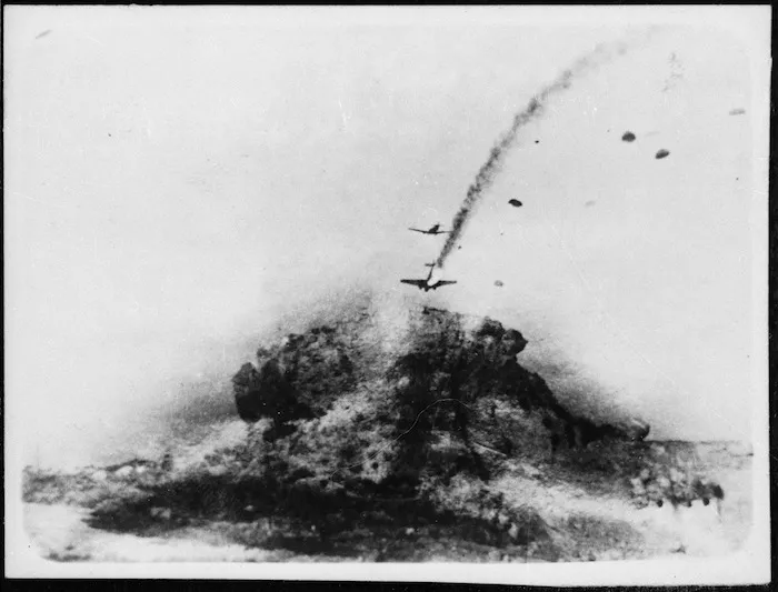 Aerial view over Crete, Greece, during World War 2, showing a German troop carrier on fire