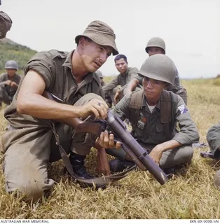 Horseshoe Hill, South Vietnam. 1969-09. South Vietnamese soldiers are given instructions on how to load an M79 grenade launcher by Private (Pte) Ron Jones of Darlington, WA. Pte Jones of B Company, ..