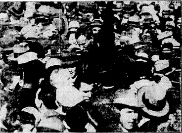 Image: The crowd about to "shoulder" Captain Kingsford Smith (cigarette in mouth) arid Mr. Ulm (with back to camera and close to his chief). : (Evening Post, 12 September 1928)