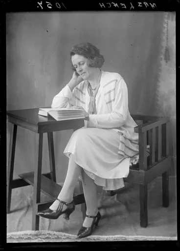 Image: Mrs Leach from Hastings reading a book seated at a small table