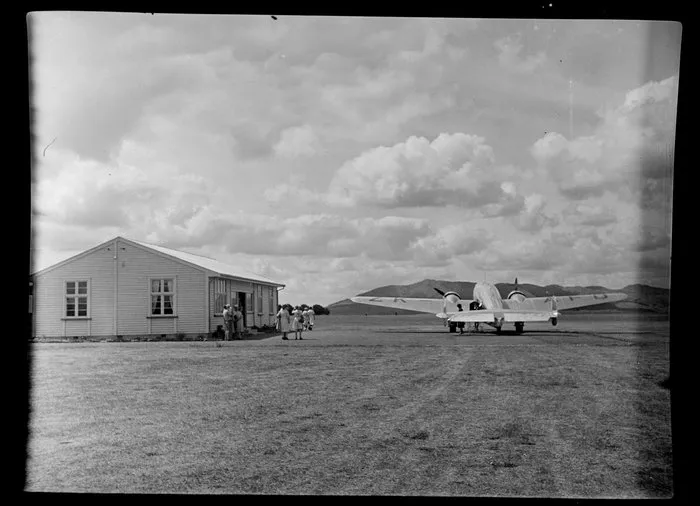 Unidentified spectators watch a National Airways Corporation plane taking off from Kaikohe Airport, Far North District, Northland Region