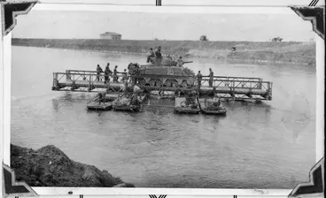 Image: New Zealand soldiers transporting a tank over the Po River, Italy, during World War 2