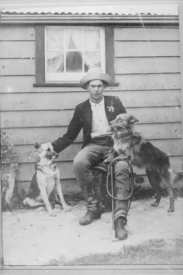 Image: Man seated outside a small building, 1909
