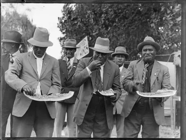 Image: Group of Maori men eating watermelon, location unidentified