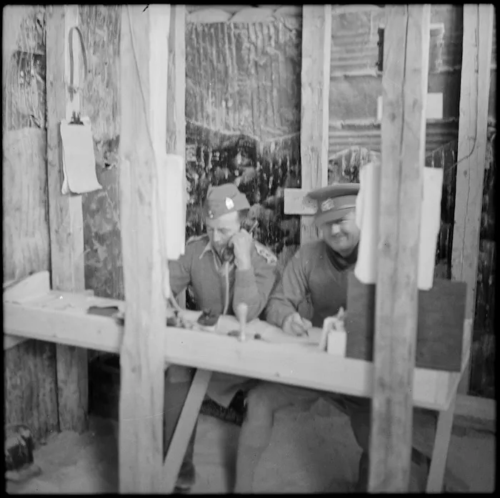 Two NZ officers at work in office dugout in the Western Desert