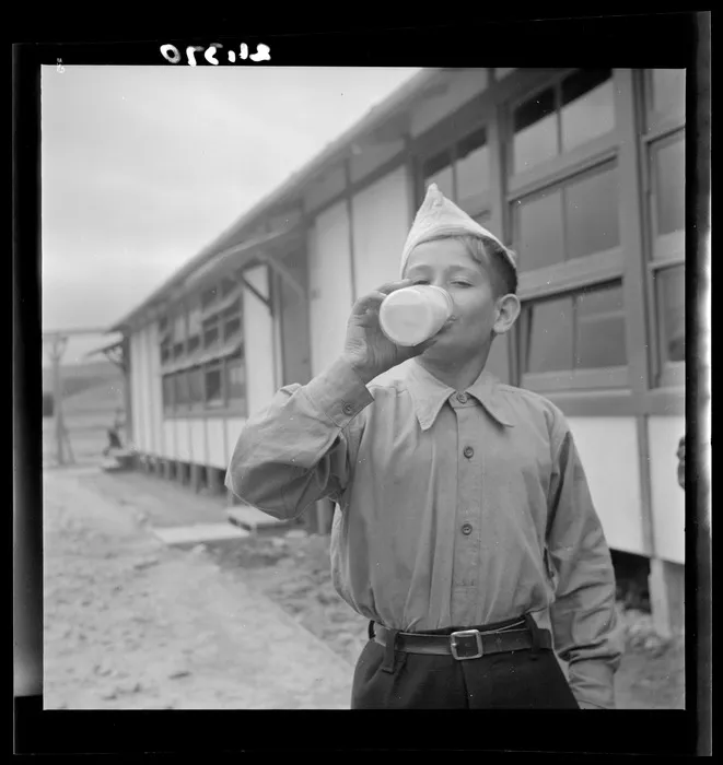 Stanisław Krejcisz drinks a bottle of milk at a Polish refugee camp, Pahiatua