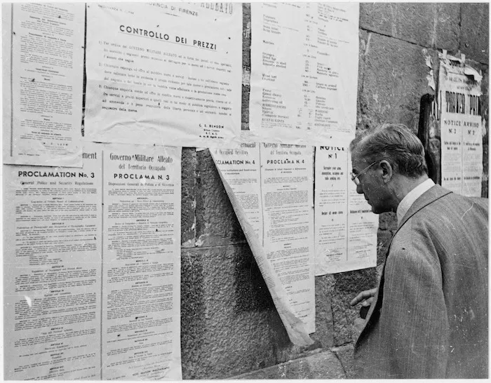 A civilian in the southern part of Florence reads the latest proclamation issued by the Allied Government in that part of the city